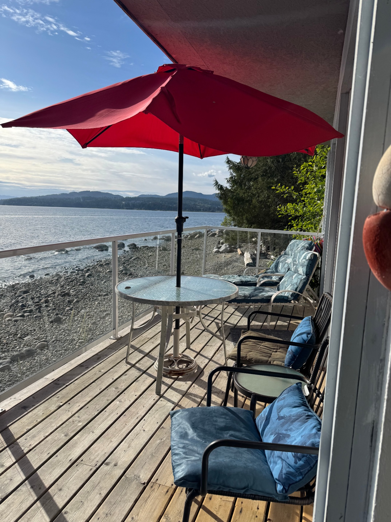 Cottage deck with red umbrella overlooking the Salish Sea