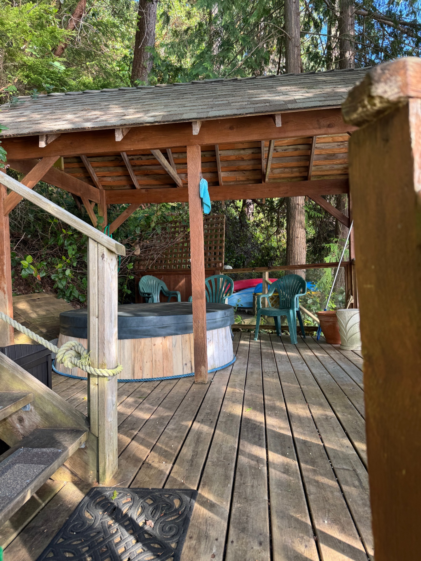 Covered cedar gazebo with hot tub among tall trees
